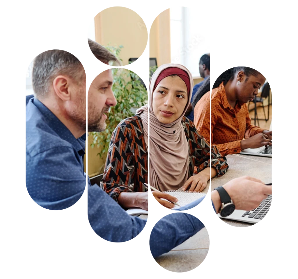 Vier Personen mit unterschiedlichem Migrationshintergrund arbeiten und beraten gemeinsam an Schreibtischen im Rahmen der Antragshilfe der Jobliment Academy